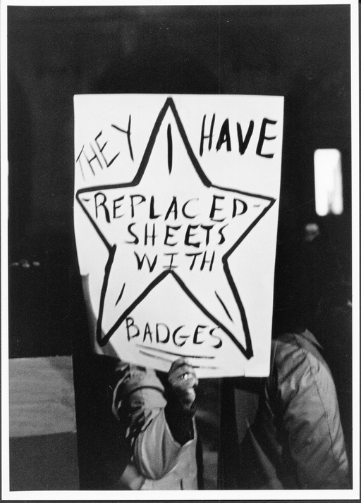A protest sign that shows the shape of a star with the words "They have replaced sheets with badges." 