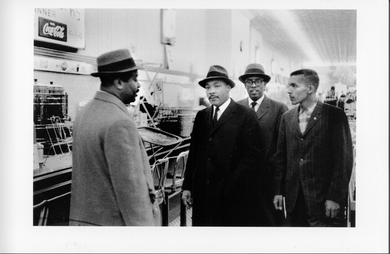 From left to right: Reverend Ralph Abernathy, Dr. Martin Luther King, Reverend Douglas Moore and an unidentified black man standing in a store. 