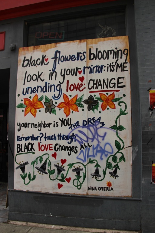 A white background with flowers and the words "black flowers blooming look in your mirror: it's me unending love: change your neighbor is you the dream remember? touch through black love changes all"